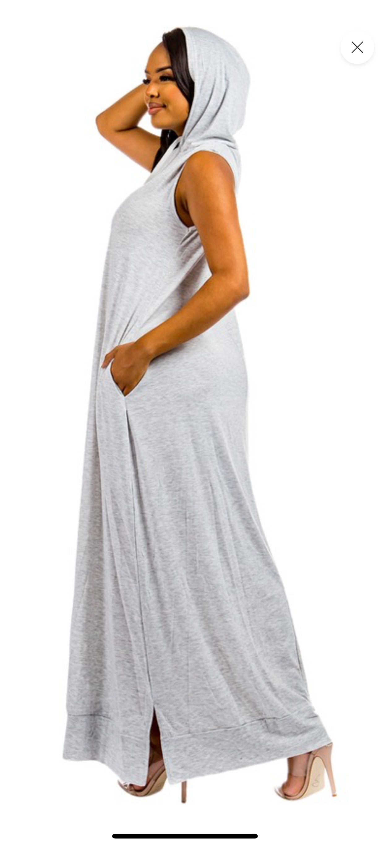 Woman wearing a long, light gray dress with a hood on a white background